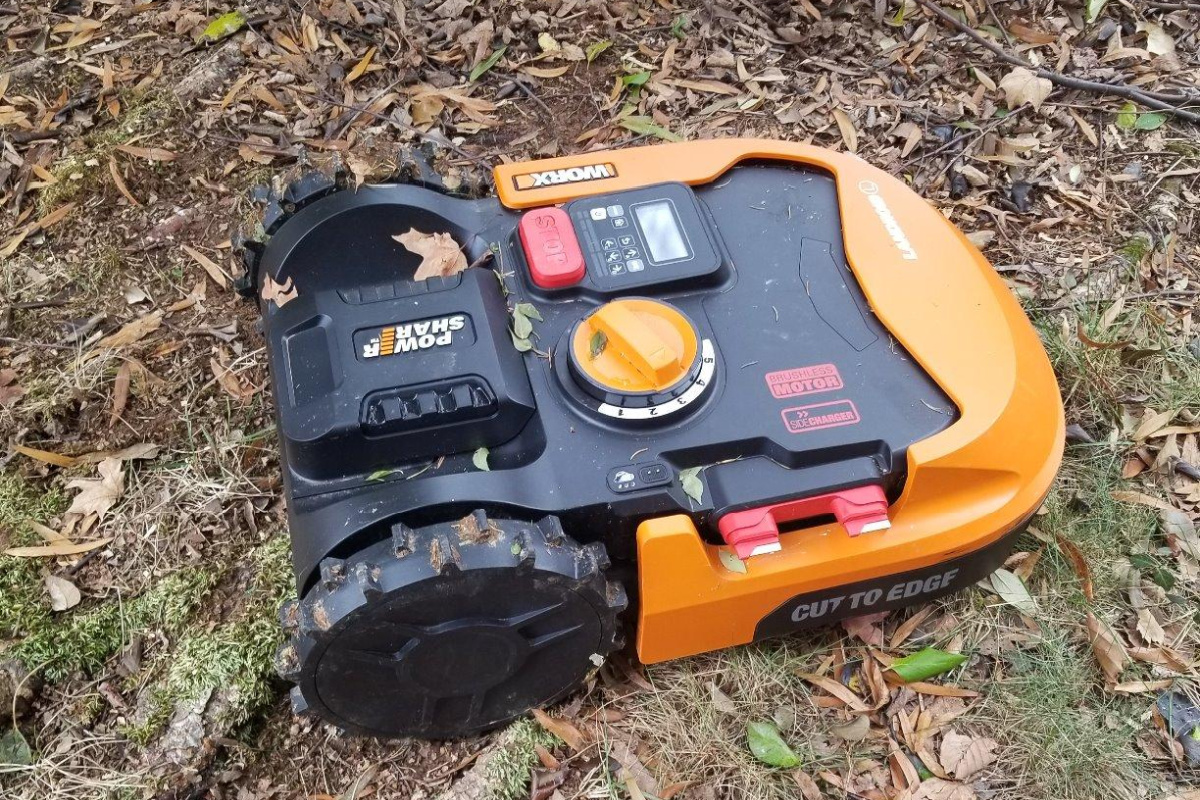 robot lawn mower on ground covered in leaves