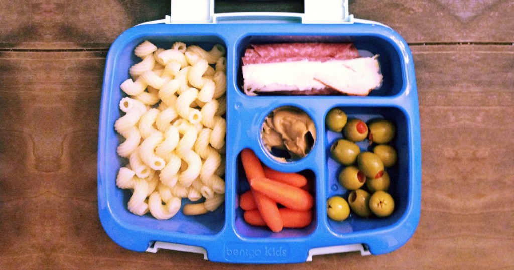 blue purple lunch box filled with food on wood surface