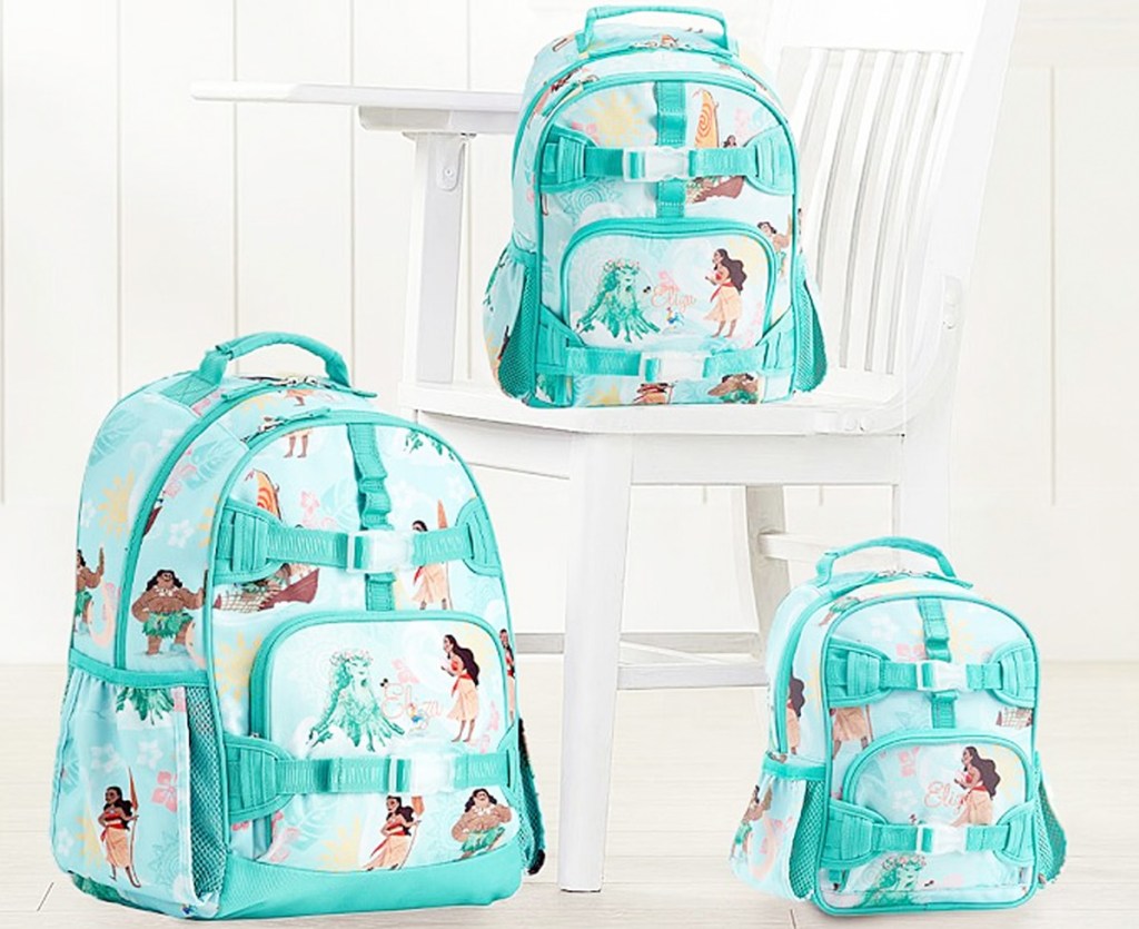 three blue disney moana print backpacks sitting on floor and white desk