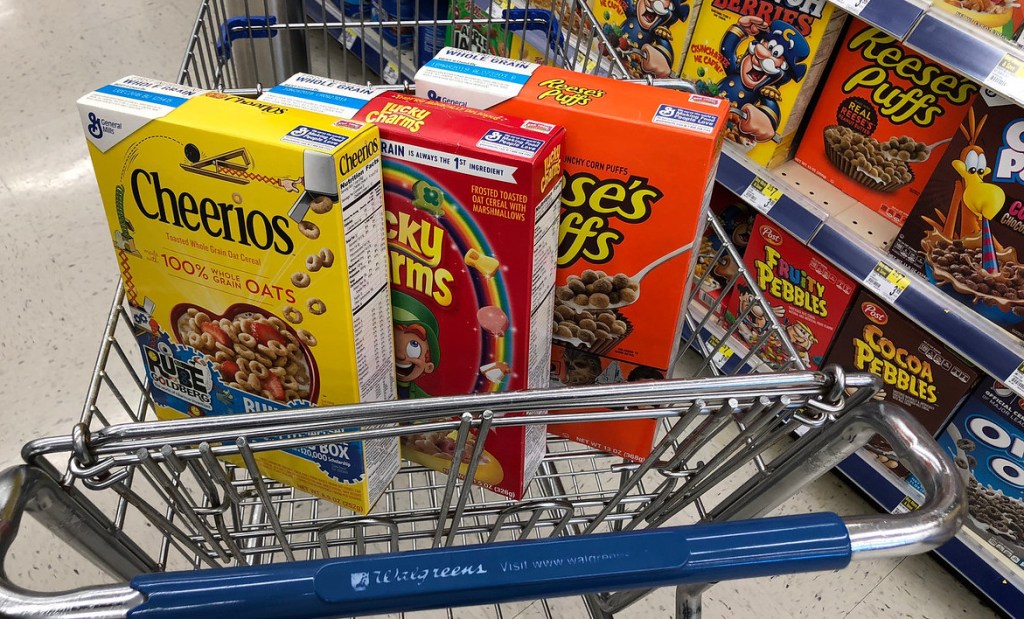 three boxes of cereal in a Walgreens cart