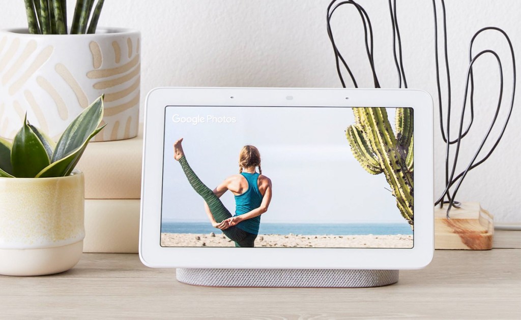 white google home smart display on table near potted succulents