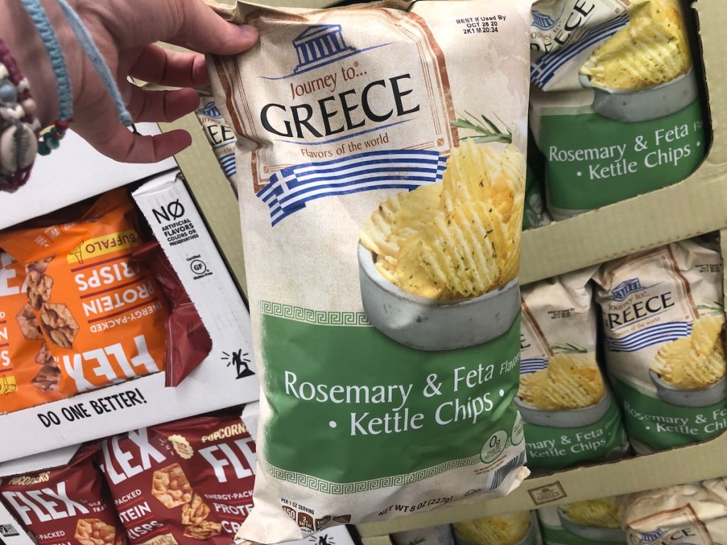 hand holding bag of Journey To... Greece Rosemary and Feta Krinkle Cut Kettle Chips