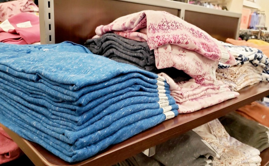 store display shelf with folded women's tees in various colors and prints