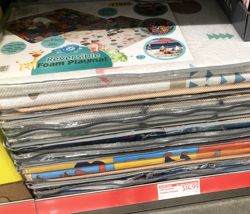 stacks of kids foam reversible play mats on a store shelf