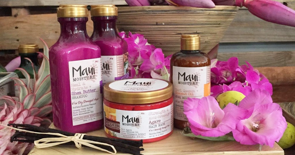 purple bottles of maui moisture hair care with purple flowers around them