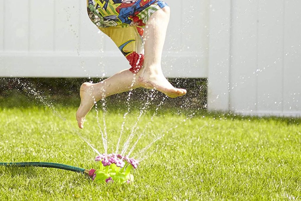 boy playing in Melissa Dog Sunny Patch Pretty Petals Sprinkler