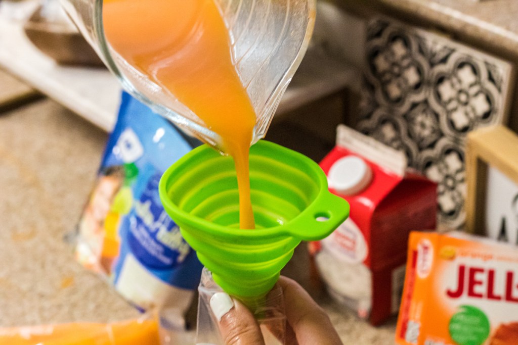 pouring popsicle mix into popsicle molds