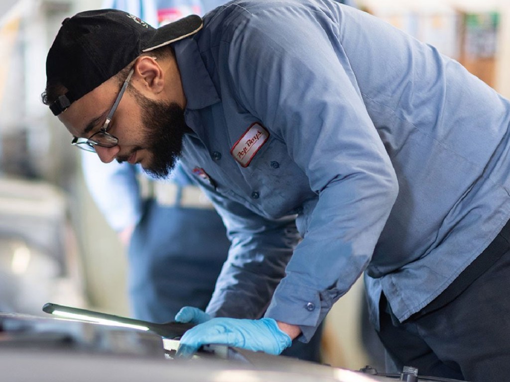 Pep Boys Mechanic leaning over car