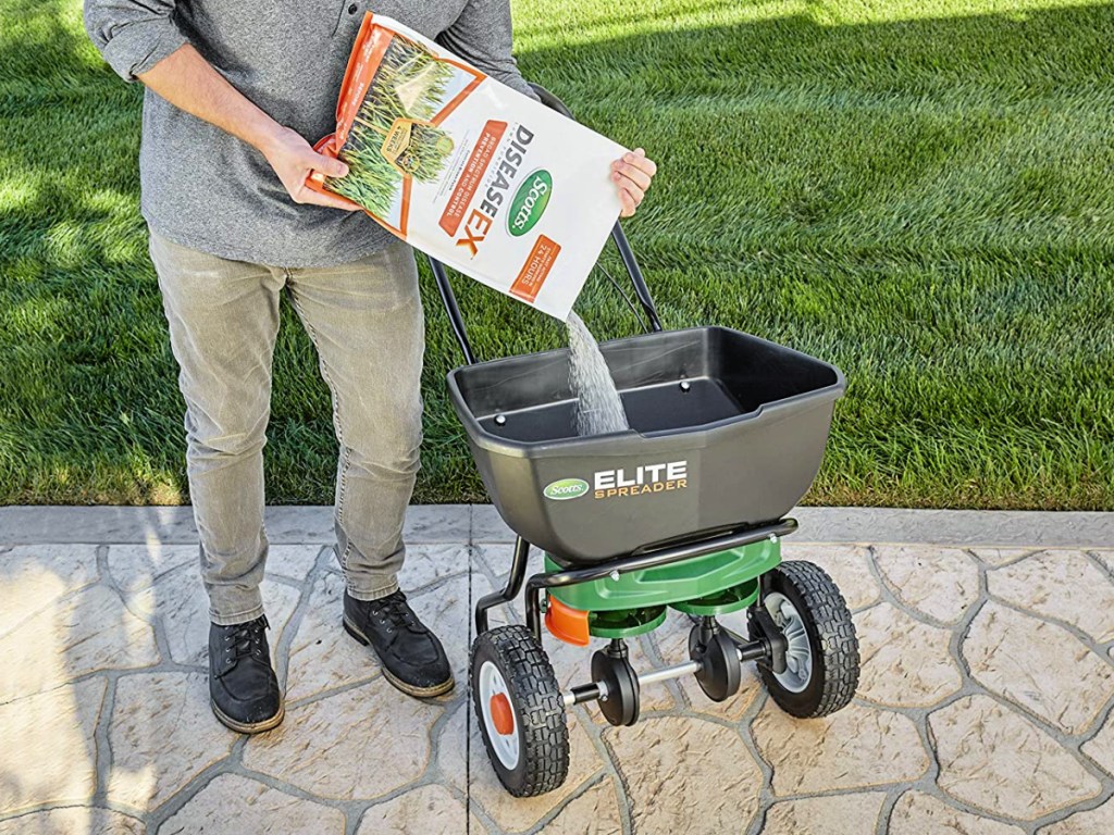 man pouring bag of Scotts DiseaseEx Lawn Fungicide into fertilizer