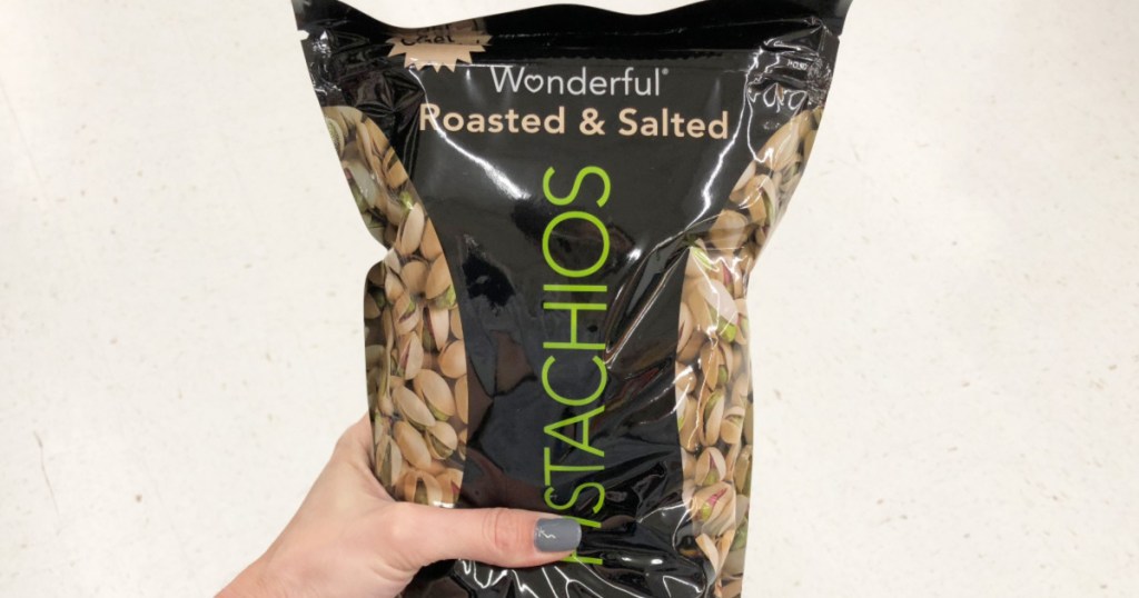 person with grey nails holding black bag os Wonderful roasted and salted pistachios