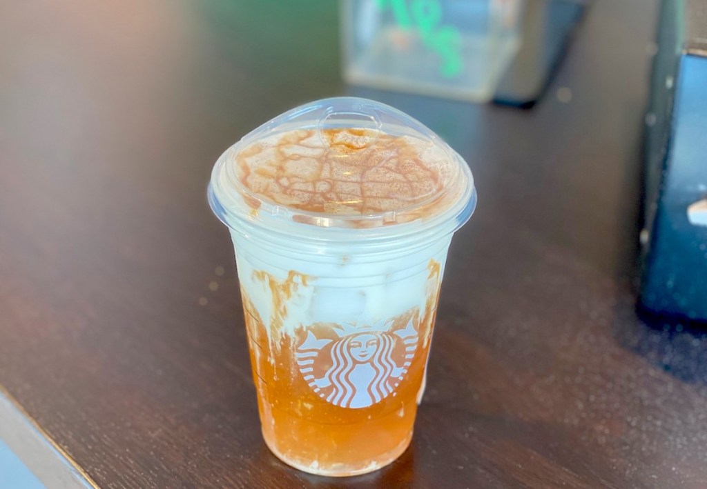 orange and white starbucks drink sitting on counter