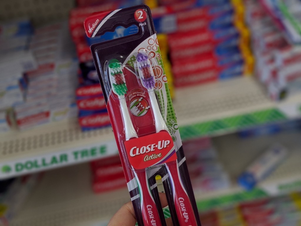 hand holding close up 2 pack toothbrushes