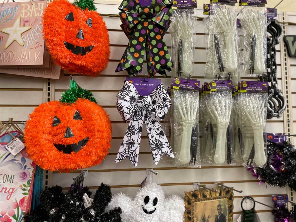 tinsel Halloween wall decor on display with ribbons and plastic skeletal hands in store