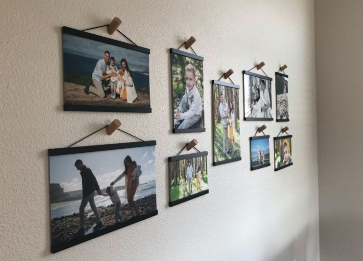 various sizes of family photos with wood frames hanging on hooks on walls