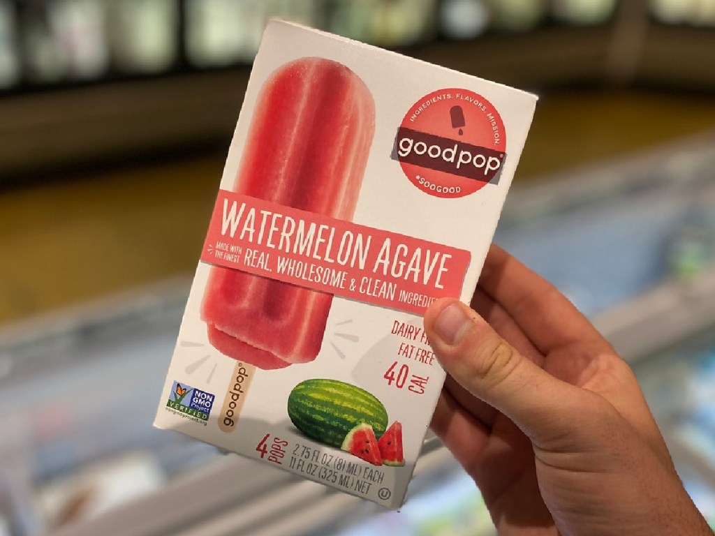 hand holding box of popsicles by store display