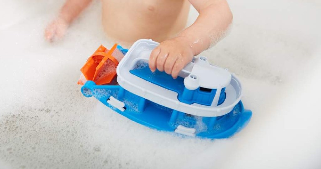 kid playing with paddle boat in bath with bubbles