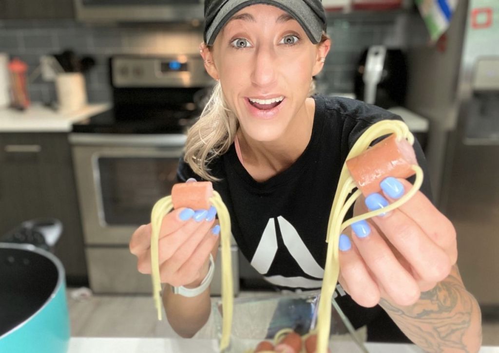 A woman holding hot dog noodles in both hands