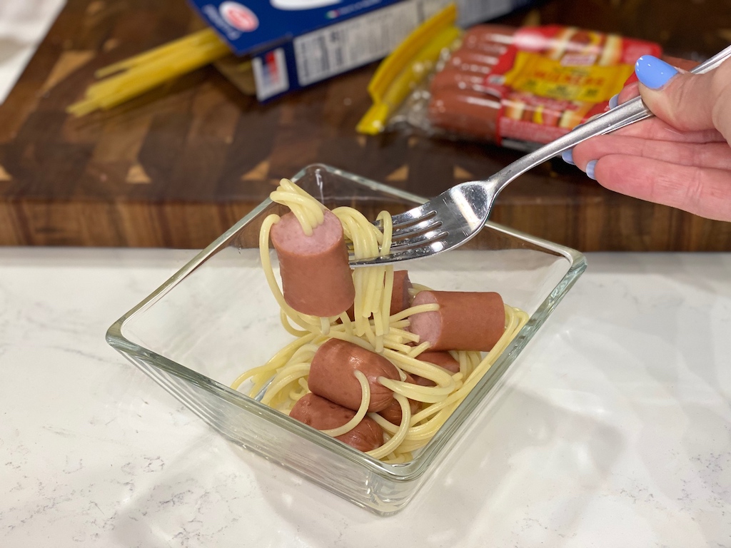 holding hot dog spaghetti on fork