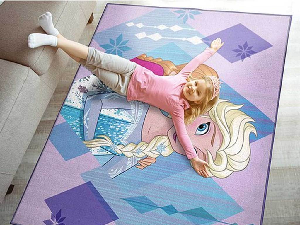 little girl laying on a rug with a disney character