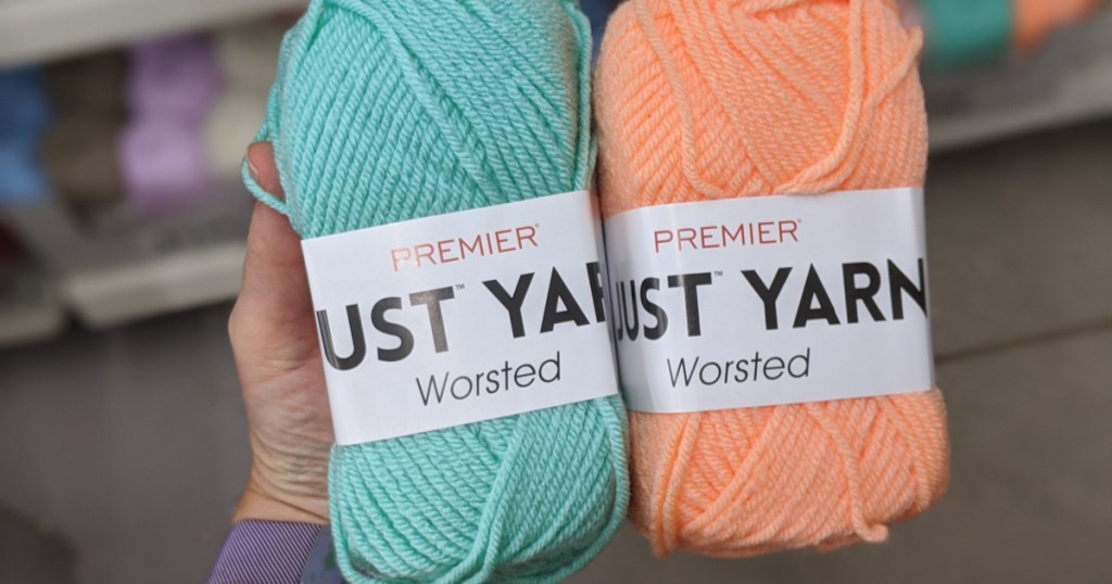 hand holding 2 yarn skeins in store