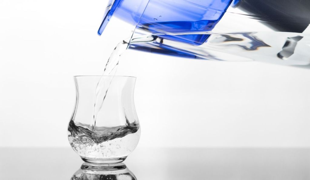 A water filter pouring into a clear glass