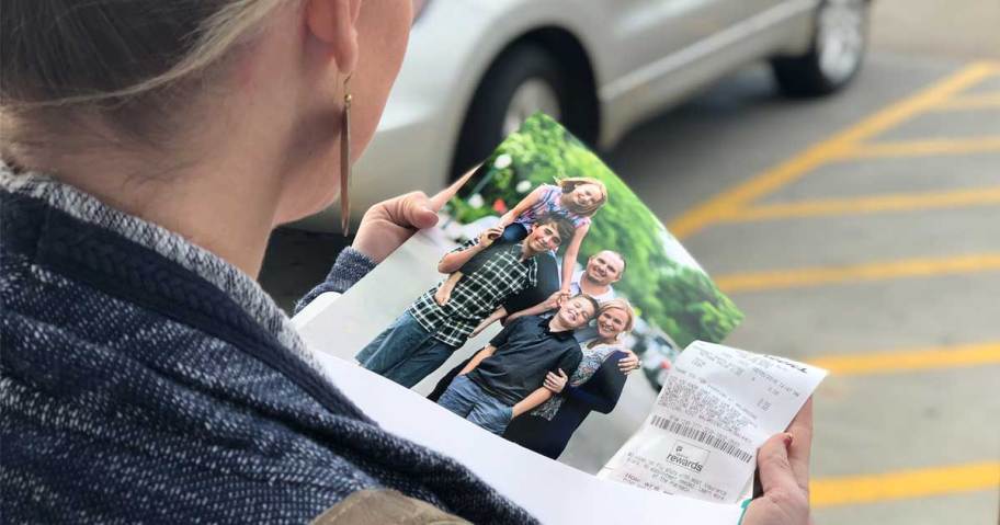 woman holding an 8x10 photo looking down on it