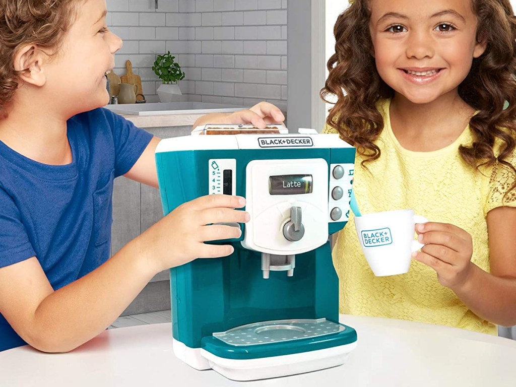 boy and girl playing with toy coffee maker