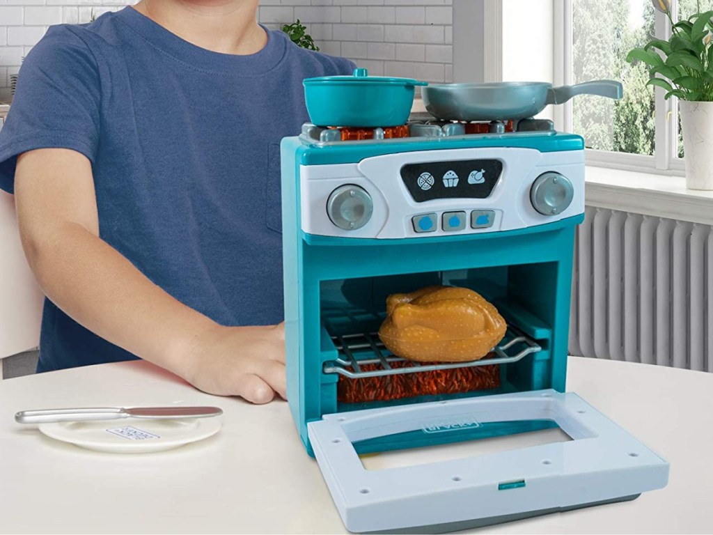 boy playing with toy oven and stove