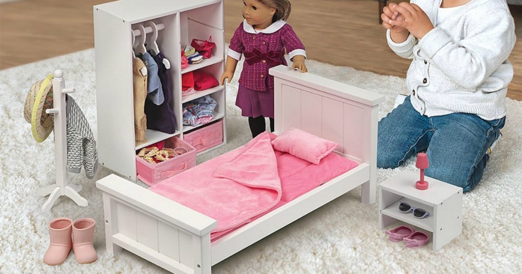 girl playing with doll and doll bedroom furniture