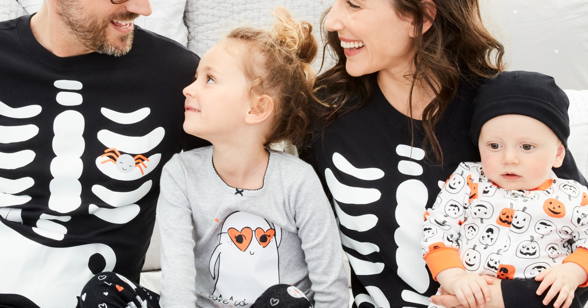 family sitting wearing carter's spooky matching pajamas