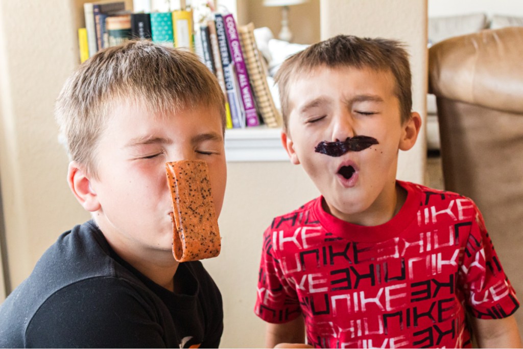 boys with fruit roll ups on face