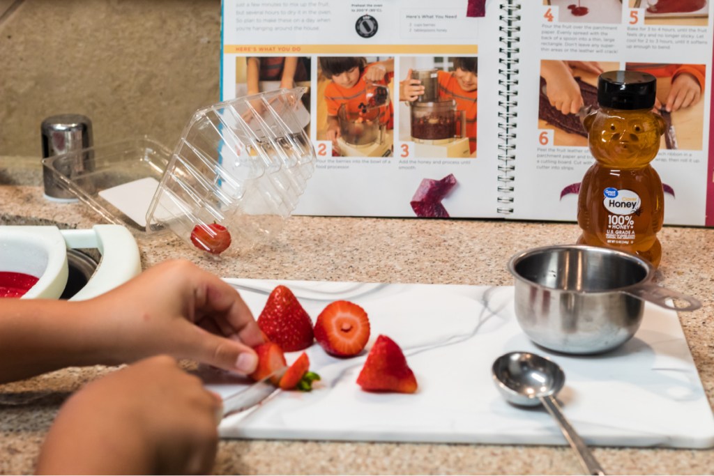 Boy cutting up strawberries