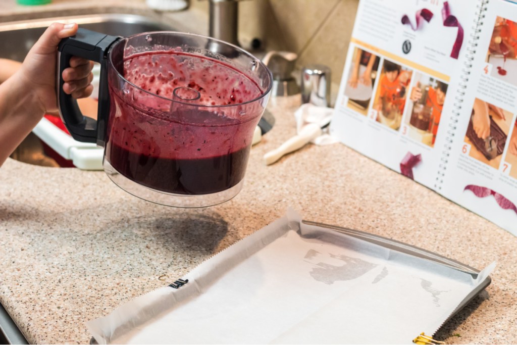 pouring blended fruit on a pan