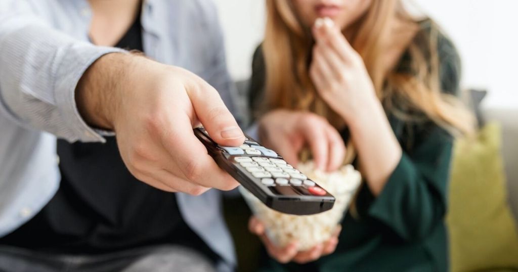 couple eating popcorn watching a movie