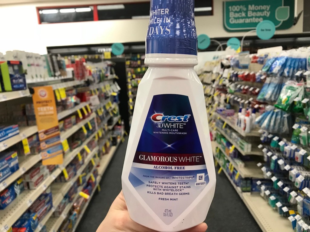 hand holding a bottle of Crest mouthwash