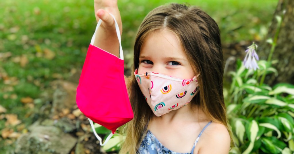 girl holding up cat and jack masks