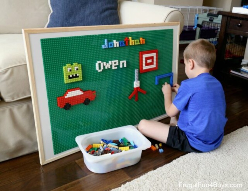 boy adding Lego pieces to vertical play surface