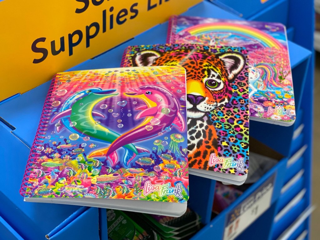 3 brightly colored Lisa Frank notebooks sitting on walmart store shelf