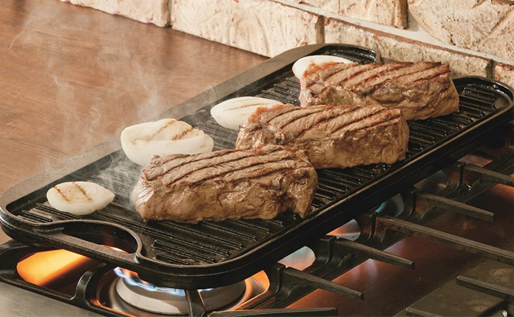 steaks and onions on grill/griddle on stove