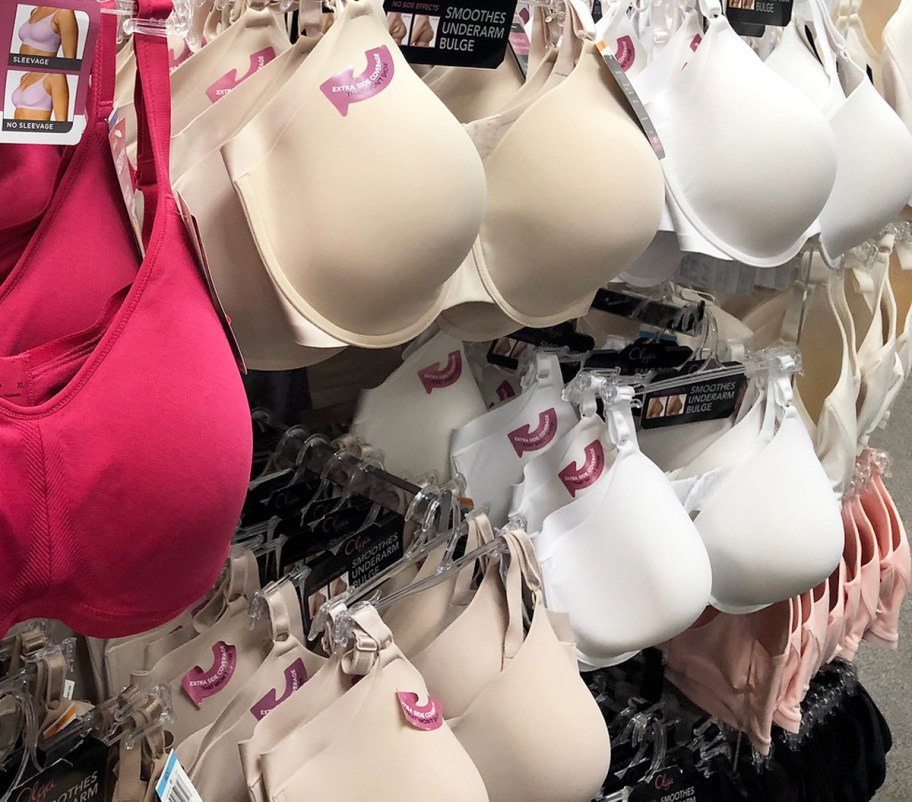 pink, nude, and white colored bras hanging on hangers on store display