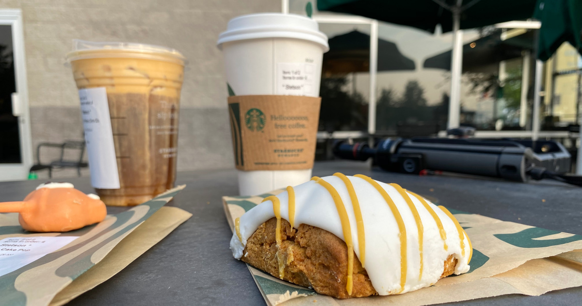 starbucks pumpkin scone on table next to fox cake pop, pumpkin spice latte, and pumpkin cream cold brew