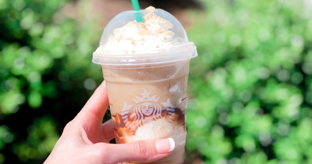 person holding up a Starbucks Frappuccino outside