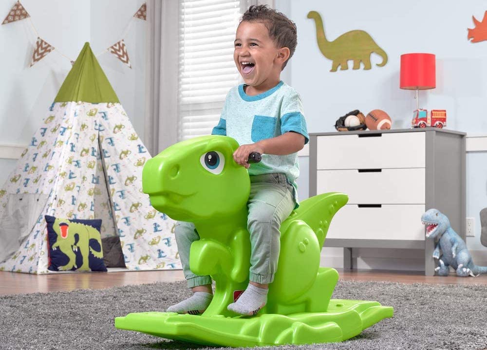 boy on a dinosaur rocker toy