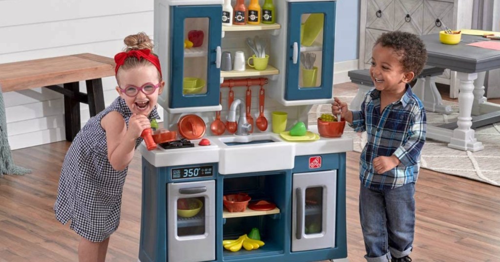 kids playing with a toy kitchen