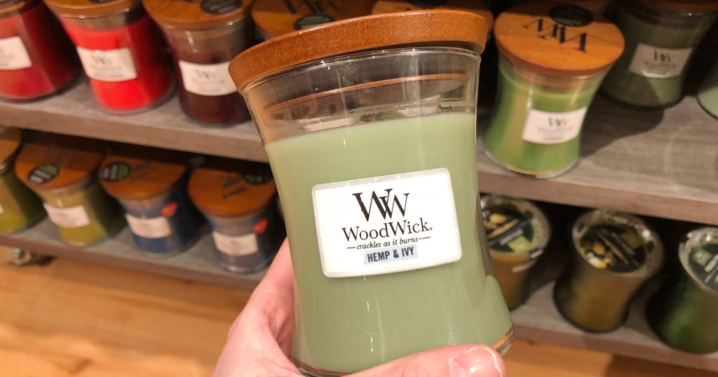 hand holding woodwick candle hemp & ivy