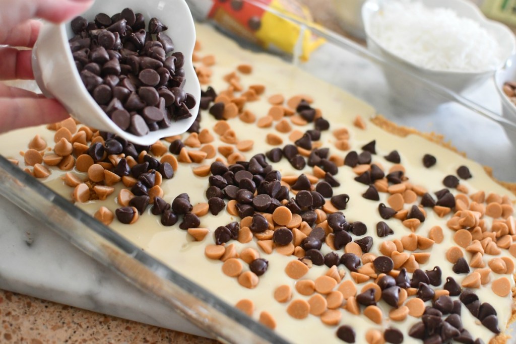 adding chocolate chips to magic bars