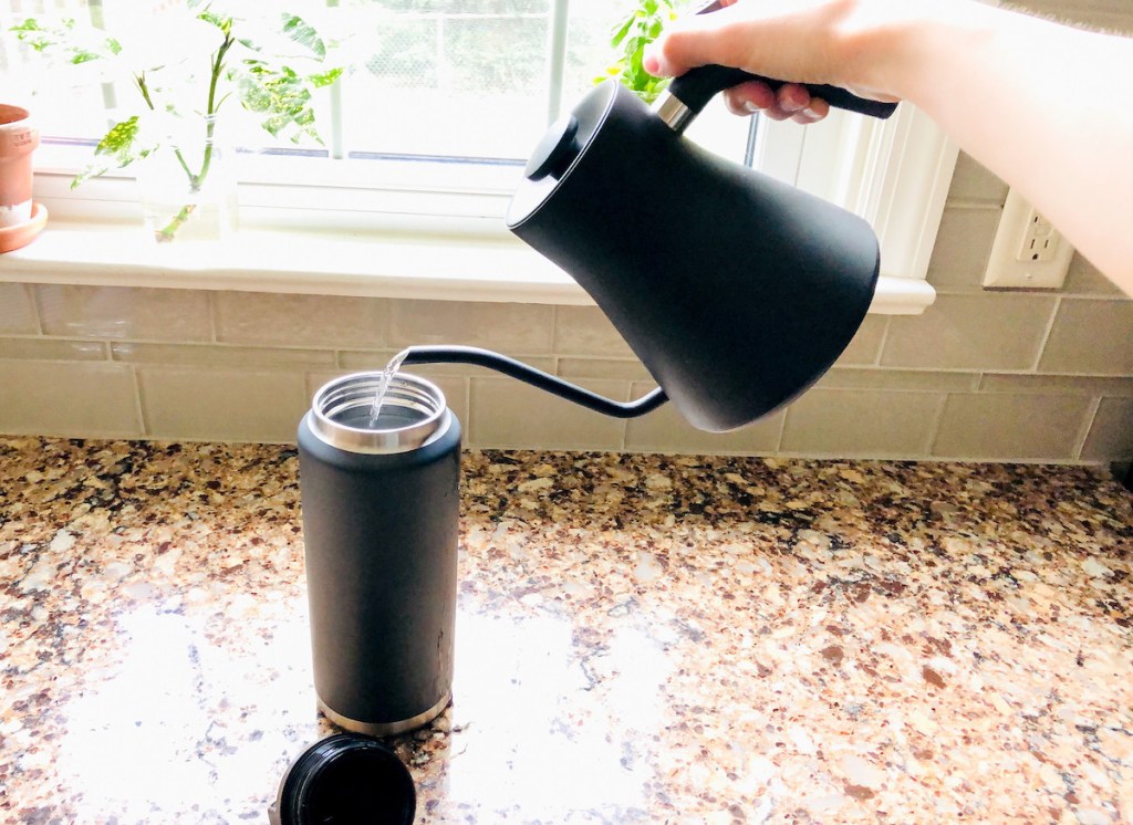 hand holding a tea top pouring water