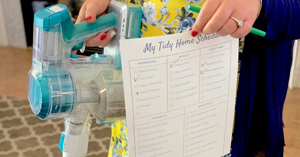 hand holding a printable chore chart and vacuum 