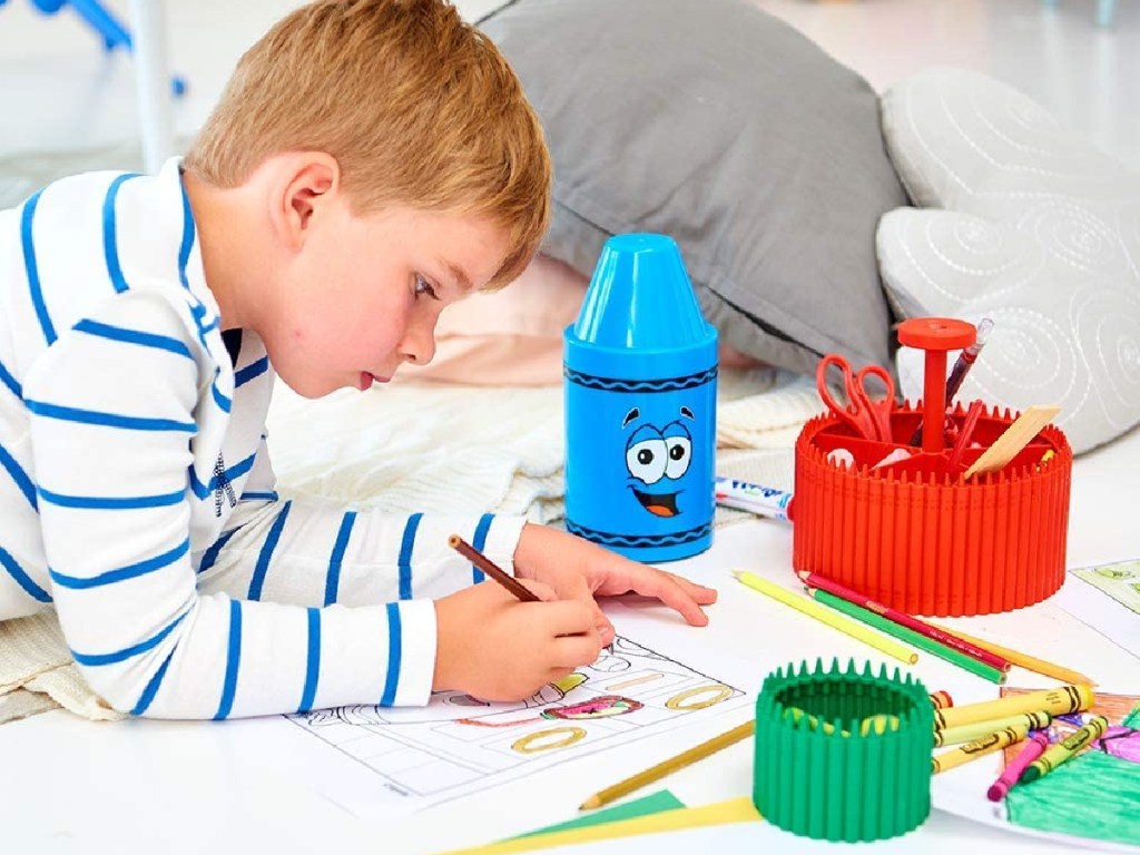 boy coloring on floor with crayons