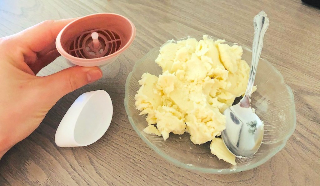 hand holding an empty container next to natural deodorant on plate